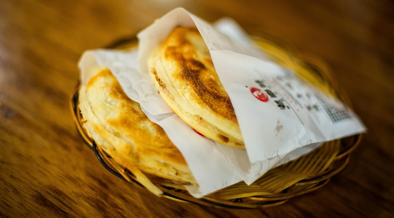 ロージャーモー（肉挟饃）— 焼き上げた平焼きパン（馍）を紙に包んでかごに盛った一品